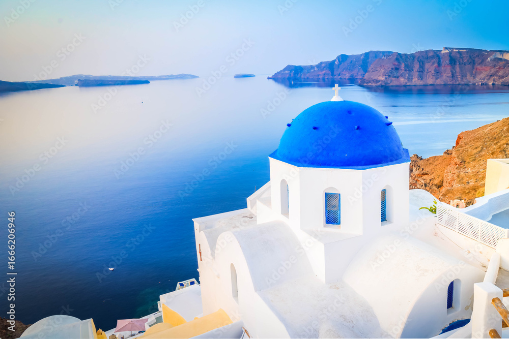 Fototapeta premium traditional greek village Oia of Santorini, with blue domes of churches and village roofs, Greece