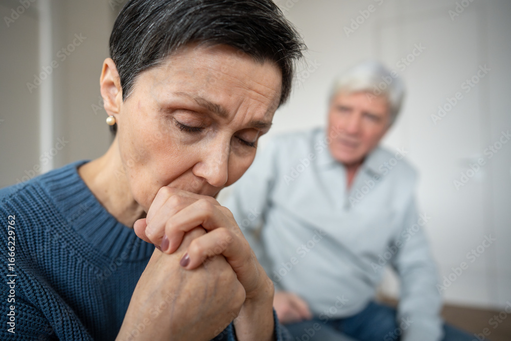 Fototapeta premium Close up depressed sad woman turned away from husband, in emotional withdrawal, hurt feelings. Senior couple discord, marital tension, silent resentment, relationship breakdown, unspoken grievances