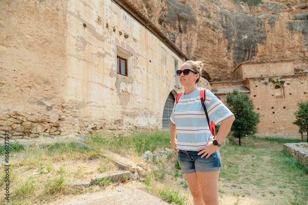 Fototapeta premium Tourist exploring ancient monastery in picturesque landscape