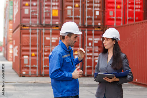 Team of engineers or workers at a container yard discussing seriously and shaking hands to symbolize teamwork and business success.