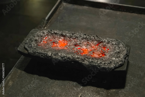 Obraz na plátně still red with heat, bar of gold covered with slag in a mold for