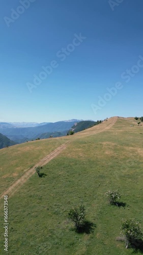 Aerial drone footage showing winding dirt roads across a mountain rural area, symbolizing countryside travel, adventure and outdoor exploration.
