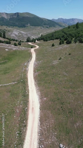 Aerial drone footage showing winding dirt roads across a mountain rural area, symbolizing countryside travel, adventure and outdoor exploration.