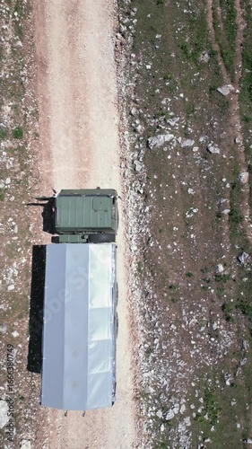 Aerial drone view of a TAM truck driving along rough mountain dirt roads, representing adventure travel, rural transport and off-road experience in nature.