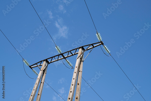 A view of an electric tower with power lines and ceramic insulators