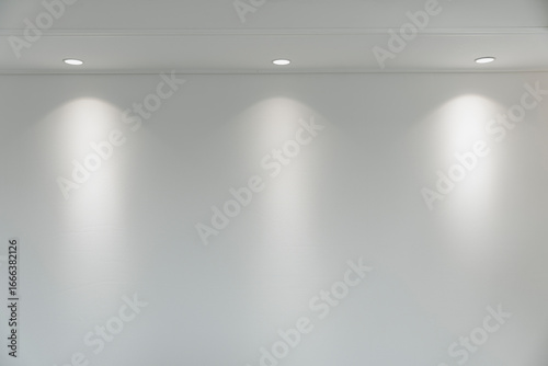 Foto Modern room interior with recessed lighting illuminating a minimalist white wall, creating a bright space