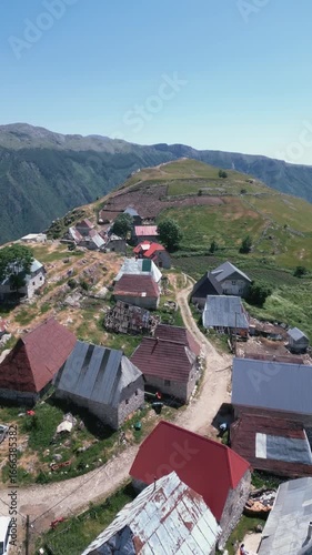 Aerial drone footage flying over traditional stone houses in Lukomir, the highest village in Bosnia and Herzegovina, located on mountain Bjelašnica. Scenic rural settlement with panoramic mountain lan