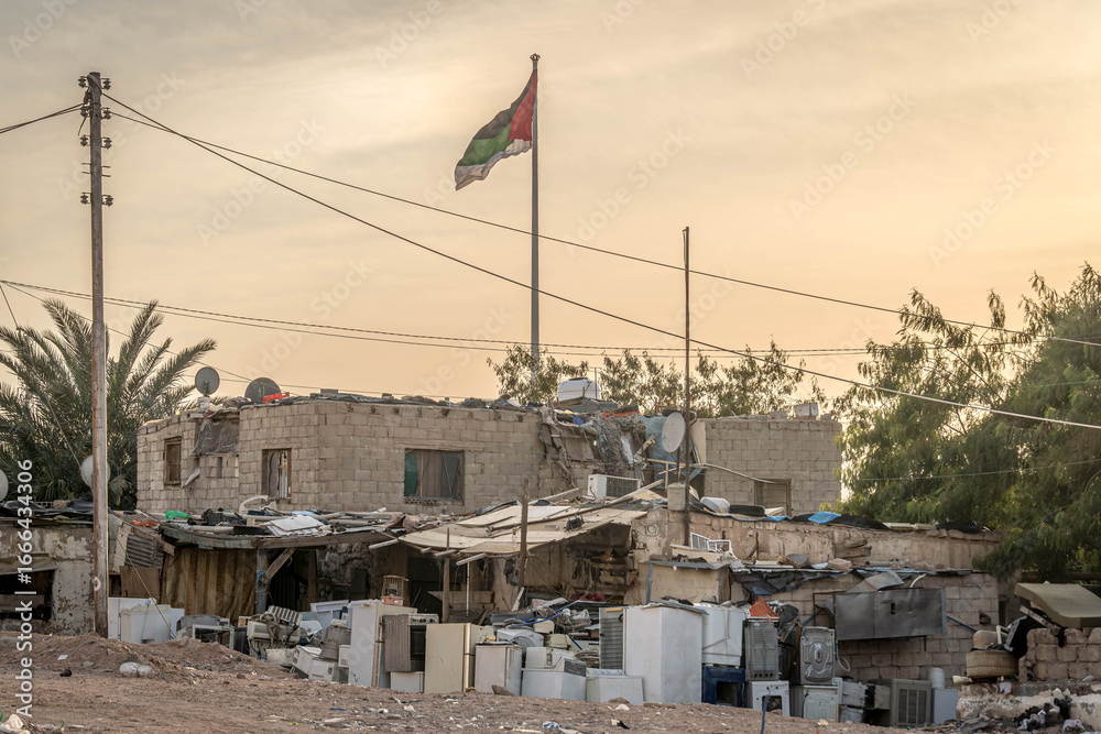 Fototapeta premium Flag of Palestine in a poor, underdeveloped area of the Middle East, during the conflict in Palestinian Gaza, among the ruins and debris. 