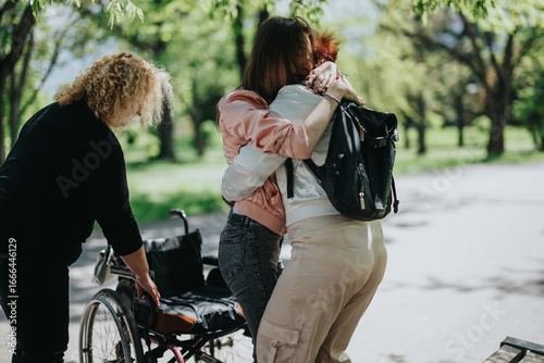 фотографія Two women supporting another woman transitioning to a wheelchair in a park, emphasizing compassion and assistance in outdoor care settings