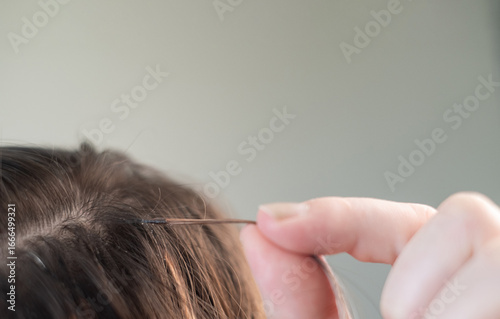 Close up of young woman with combined hair color after capsule extension procedure in beauty salon