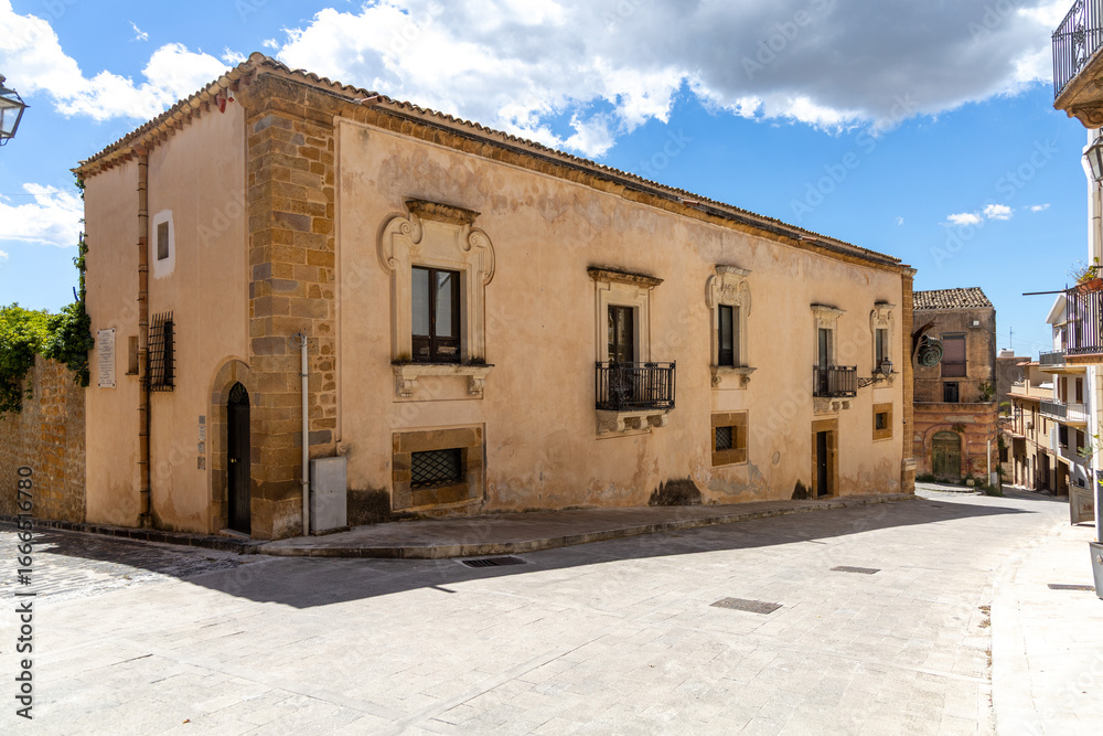Fototapeta premium Traditional stone building on a quiet street corner in Sambuca di Sicilia, a historic hill town in Sicily in southern Italy.