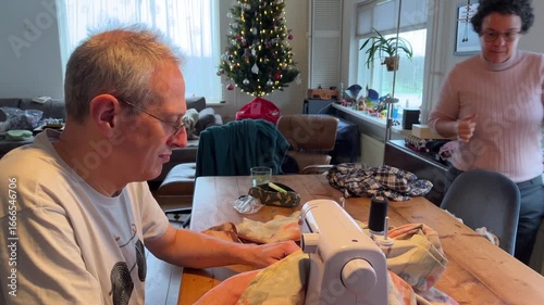 Mature adult tailor is sewing an año viejo doll, a Latin American Ecuadorian tradition representing the old year, in preparation for New Year's Eve celebrations in Amsterdam, Netherlands.
