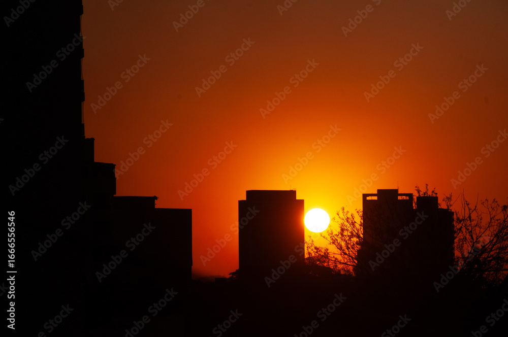 Obraz premium Por do sol entre predios