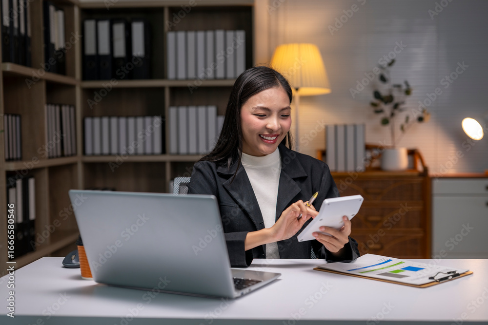 woman is sitting at a desk with a laptop and a calculator woman is sitting at a desk with a laptop and a calculator