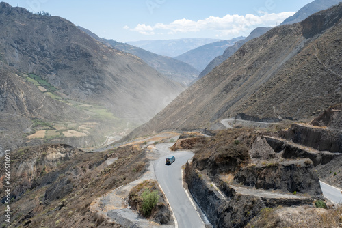 Obraz na plátně A green 4x4 campervan driving down a very winding road with the valley below