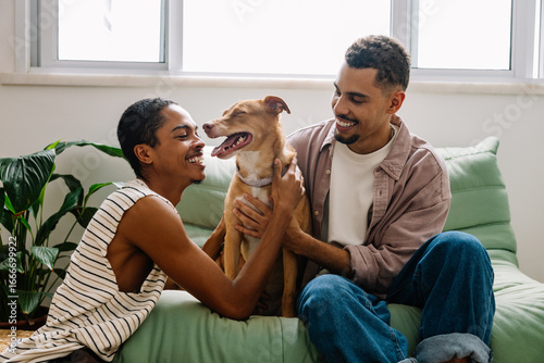 Canvas Print Gay couple bonding with caramel rescue dog at home