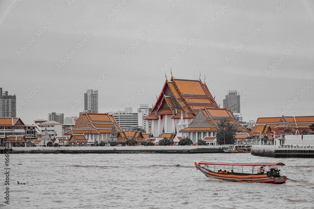 Obraz premium Bangkok, Thailand - December 9, 2024 : Chao Phraya river view of Bangkok, Thailand's Wat Arun. The Buddhist temple is a well-known tourist destination in Thailand and a landmark in Bangkok.