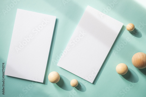 Empty white blank greeting or invitation card with wooden ball on blue background. Mock up presentation.