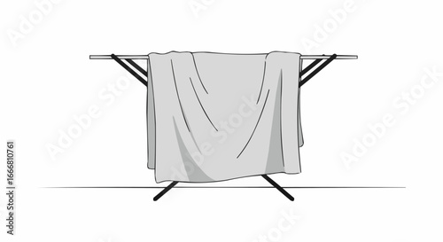 Clothes drying rack with gray blanket draped over it  