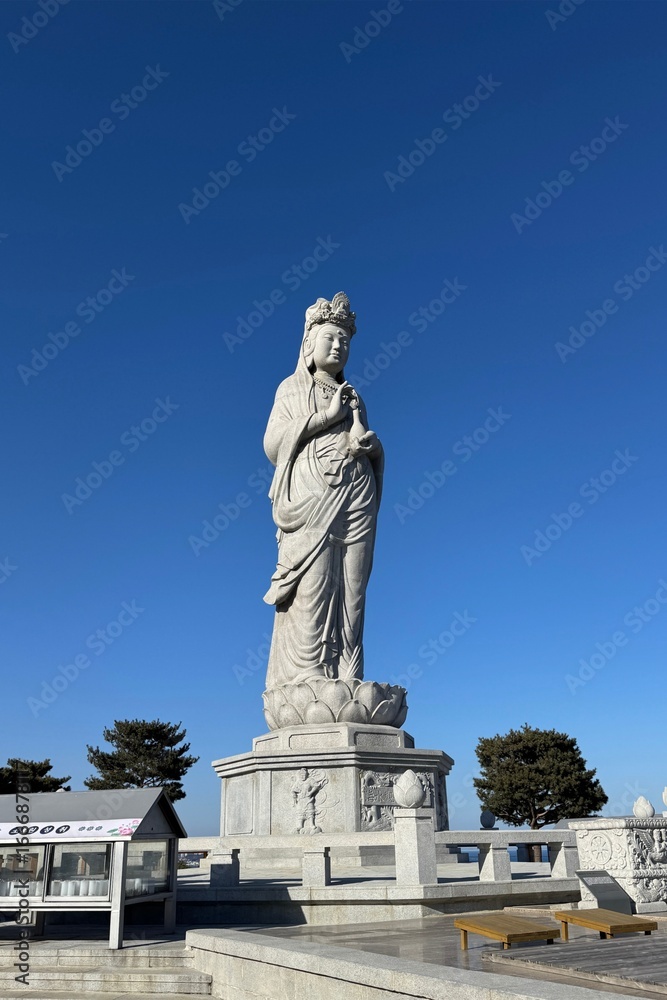 Obraz premium Large outdoor Buddhist statue under clear blue sky