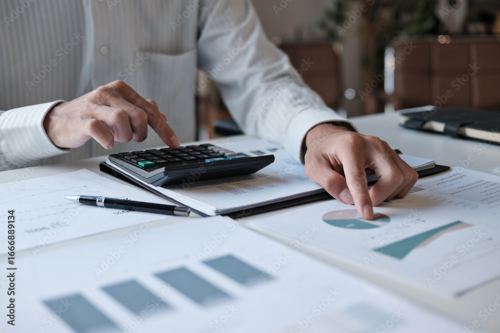 Fototapeta premium Administrative staff reviewing company budget report with calculator, document stack and focus at office desk