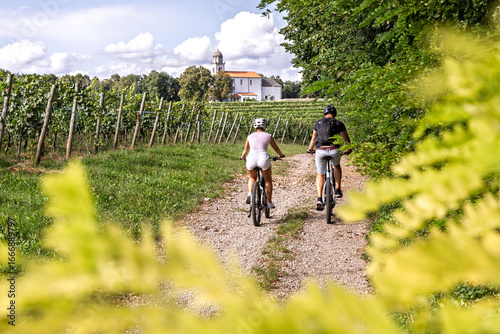 Couple cycling through Karst vineyards in Komen