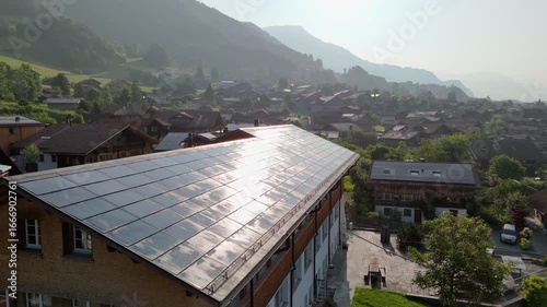 Solar Panel Roof on the Building in Swiss town surrounded my Alps Mountains. Renewable Energy in Brienz, Switzerland