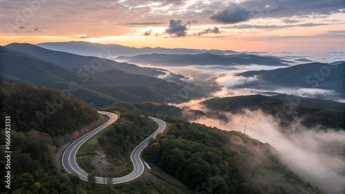 Aerial View of Winding Mountain Road at Sunrise with Misty Valleys