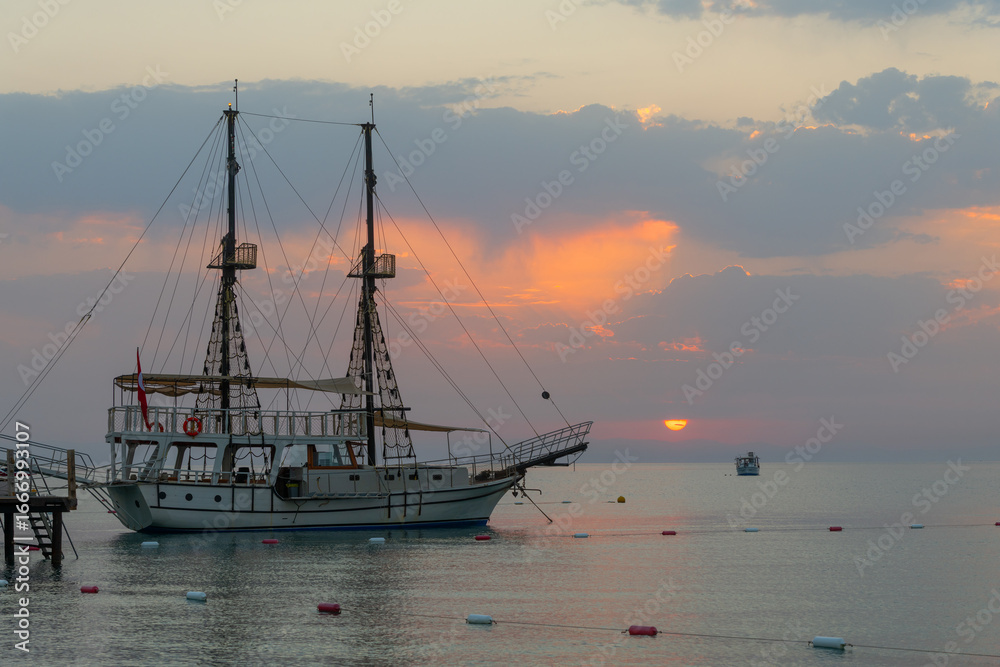 Naklejka premium A pleasure yacht with two masts at its berth in the Turkish province of Antalya on a picturesque early summer morning
