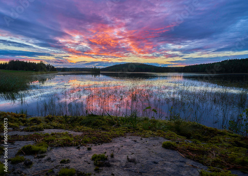 Dramatic colorful sunset over tranquil lake with reflections, perfect for peaceful nature backgrounds and landscapes