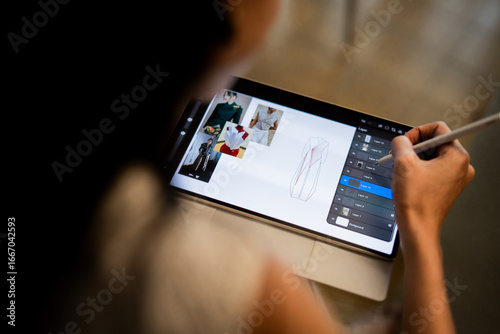 A designer uses a digital tablet and stylus to create fashion sketches with dress patterns and fabric inspiration, highlighting modern design technology