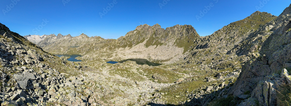 Obraz premium Hiking trail winding through picturesque pyrenees mountains with sparkling lakes.