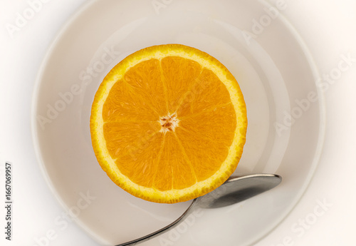 Half Orange Slice on White Plate with Spoon – Healthy Food Concept