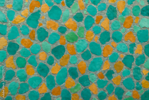 Mosaic of teal and orange pebbles creating a vibrant abstract pattern