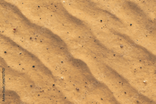Close up of rippled desert sand with subtle shadows and texture