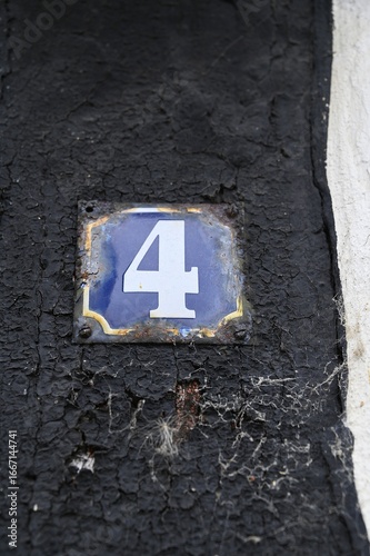 Old number 4 metal sign on house in Denmark.