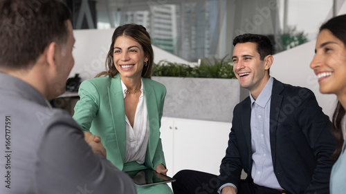 Foto Smiling Hispanic business woman shaking hands with man colleague or shareholder