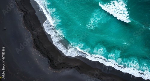 Aerial view of turquoise ocean waves breaking on a dark sand coastline