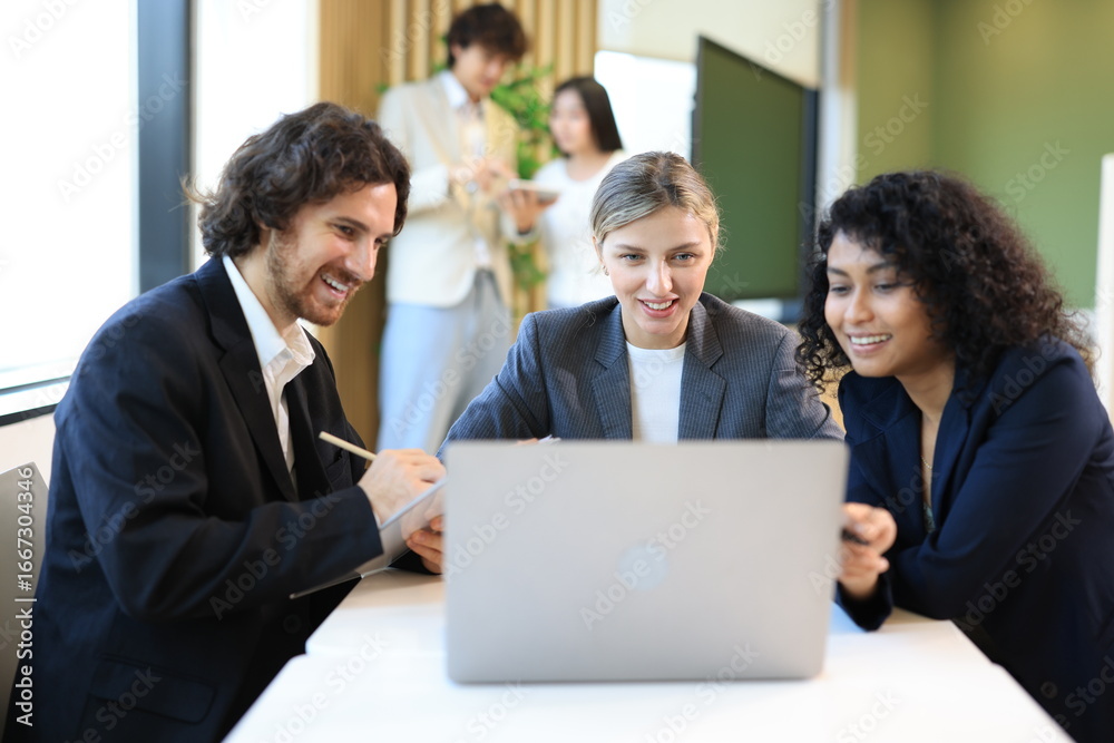 Diverse Team Working Together in Modern Co-Working Space. Casual meeting of smiling diverse business team analyzing financial data. Multiethnic business people working together in the office. Diverse Team Working Together in Modern Co-Working Space. Casual meeting of smiling diverse business team analyzing financial data. Multiethnic business people working together in the office.