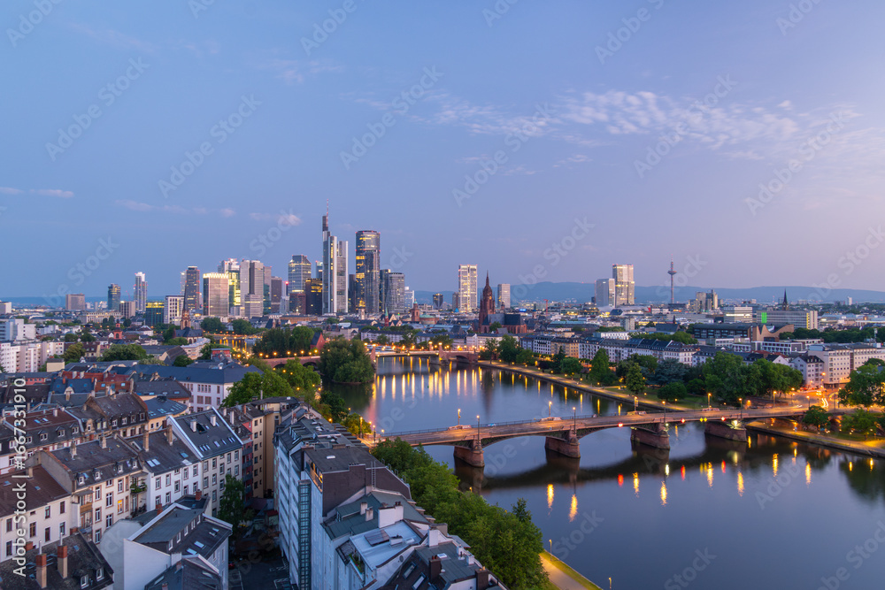 Obraz premium Illuminated Frankfurt City Downtown, Residential Buildings, Bridges and Main River at Morning Twilight. Wide Shot. Aerial View. Blue Hour. Hesse, Germany