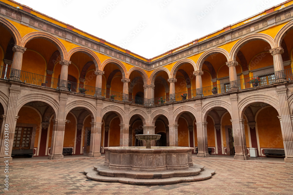 Fototapeta premium Colonial courtyard with central fountain and arched galleries in former monastery in Queretaro, Mexico