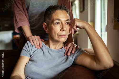 Stressed woman receiving comforting support from her lesbian partner at home