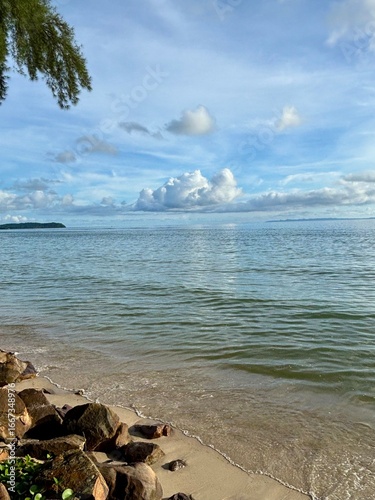 Beach horizon under a clear blue sky with clouds, representing relaxation and the journey of life