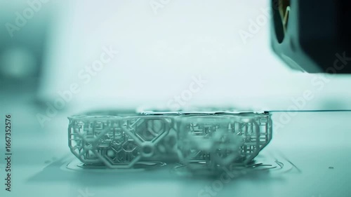 Close-up 4k video of a 3D printer creating a translucent plastic object, showcasing the additive manufacturing process in a clean, modern laboratory with a cool, teal