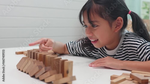 Focused girl playing and learning with wooden blocks