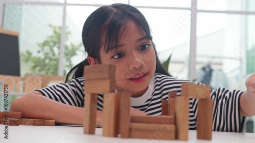 Focused girl playing and learning with wooden blocks