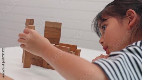 Focused girl playing and learning with wooden blocks