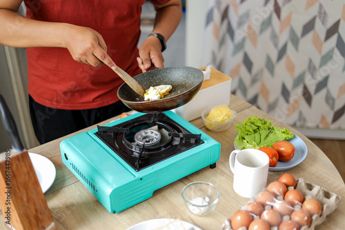 Photos Hands of Man Stirring Scrambled Eggs in Pan on Portable Stove