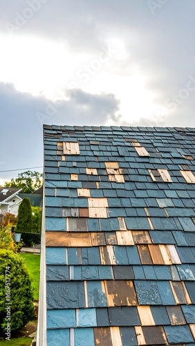 Damaged roof shingles, needing repair, showing wood underneath