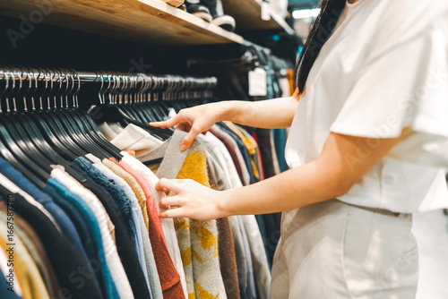 Konstfotografi Woman arm choosing used clothing at second hand clothes shop